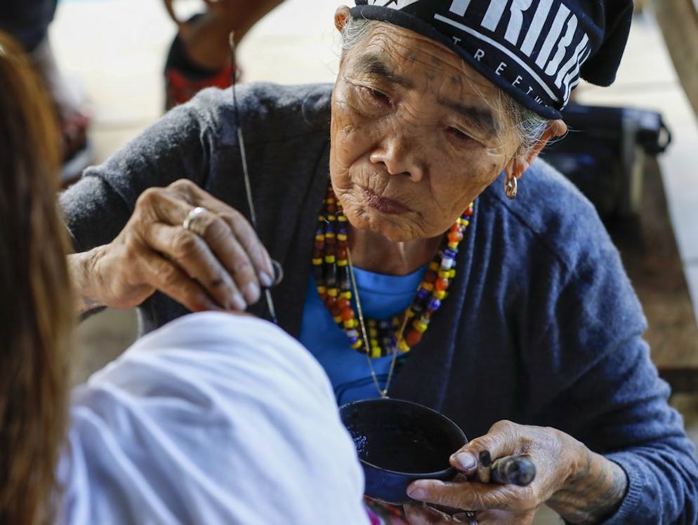Whang Od, la tatuatrice centenaria. La centenaria applica il colore senza tremare,...