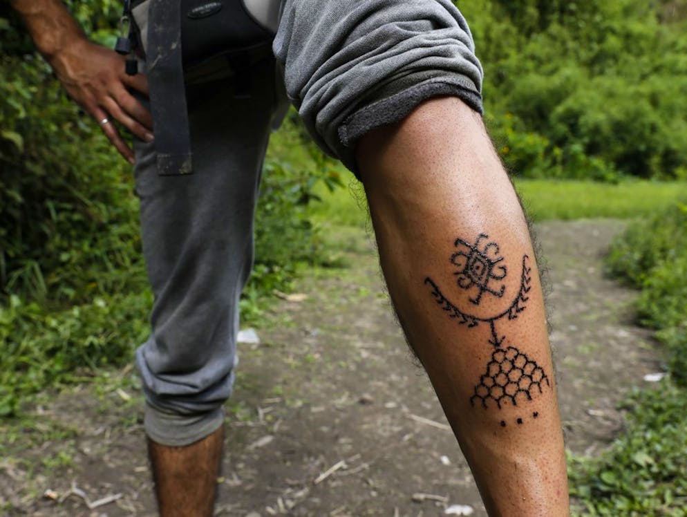 Whang Od, la tatuatrice centenaria. Questo cliente di Whang Od ha resistito alla seduta di tortura e mostra fieramente il suo nuovo tatuaggio.