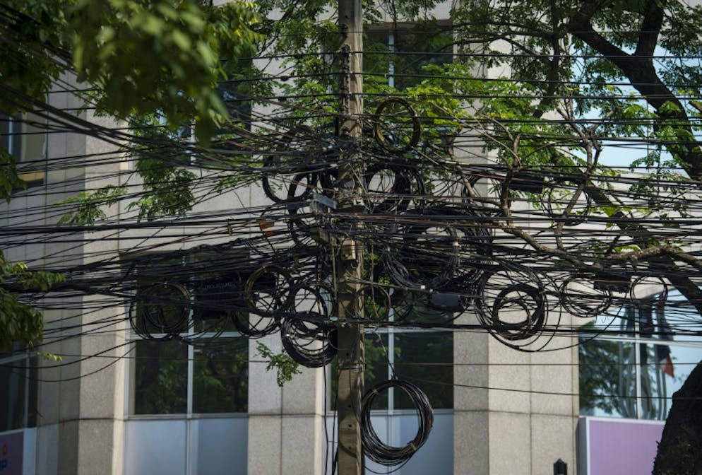 Chasse à l'anarchie des fils électriques à Bangkok. Enchevêtrement des câbles électriques à Bangkok le 3 janvier 2018