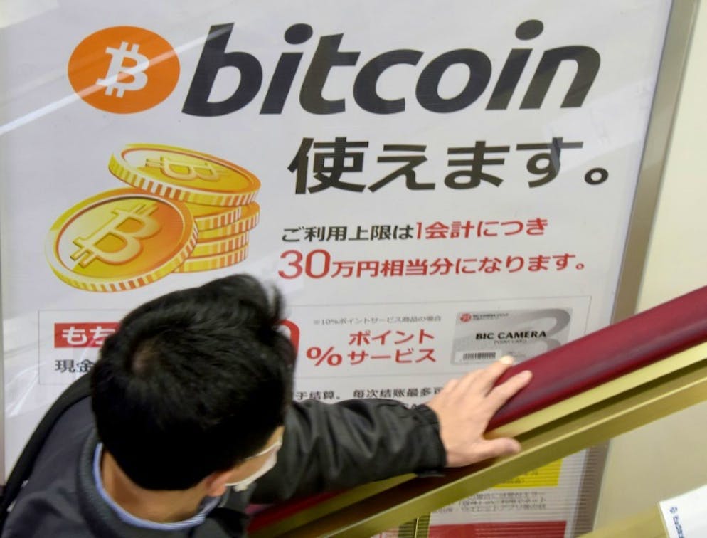 A l'ombre du bitcoin, d'autres cryptomonnaies flambent. Une affiche publicitaire d'un magasin à Tokyo indiquant que le bitcoin y est accepté, le 6 janvier 2018