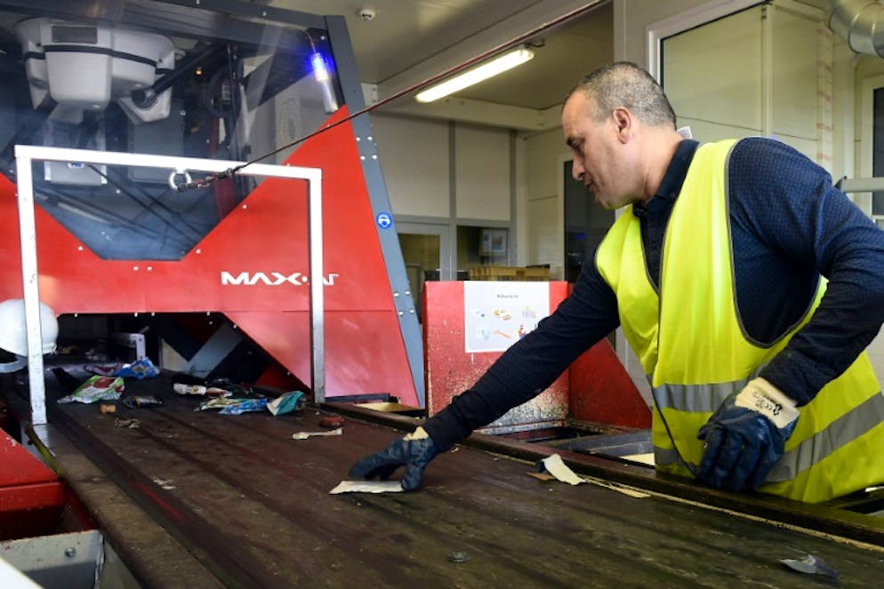 Un agent de Veolia vérifie le tri effectué par le robot Max AI utilisé sur un site du groupe à Amiens
