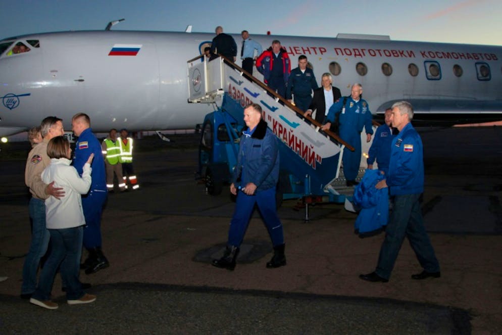 Photo fournie le 11 octobre 2018 par l'agence spatiale russe Roskosmos montrant l'astronaute américain Nick Hague et le cosmonaute russe Alexeï Ovtchinine accueillis par leurs familles et des responsables à Baïkonour au Kazakhstan