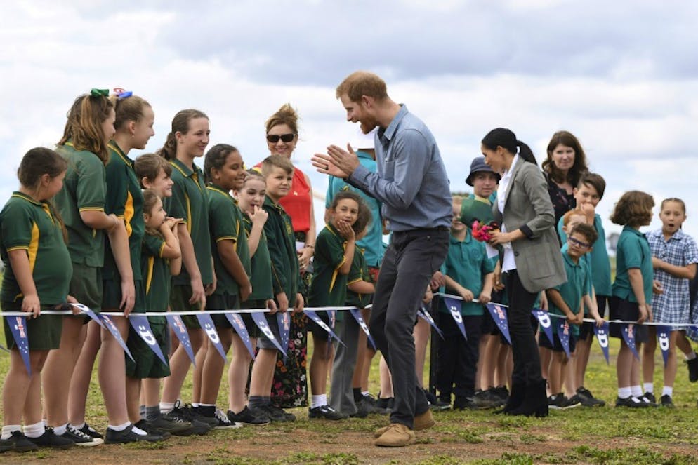 Le prince Harry et sa femme Meghan accueillis par des écoliers à l'aéroport de Dubbo, le 17 octobre 2018