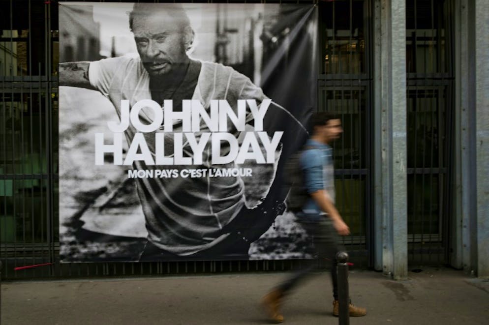 Un passant devant l'affiche de l'album posthume de Johnny Hallyday, le 15 octobre 2018 à Paris