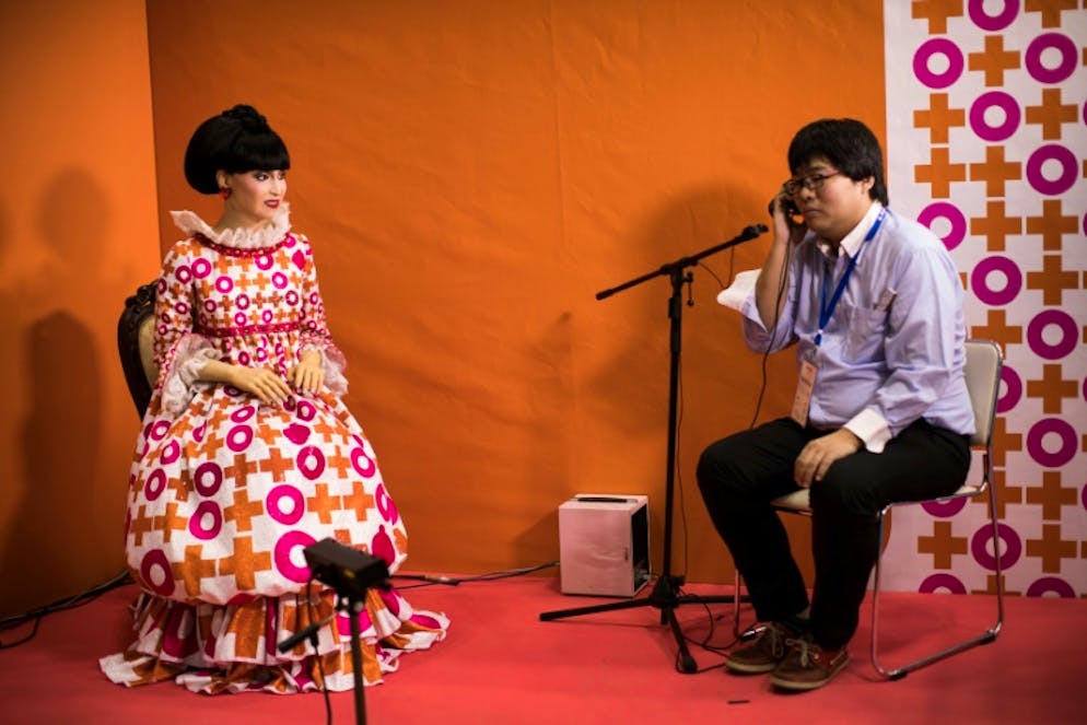 Un homme parle avec le robot androïd "totto", réplique quasi parfaite de la star de la télé japonaise Tetsuko Kuroyanagi, au salon World Robot Summit, le 18 octobre 2018 à Tokyo