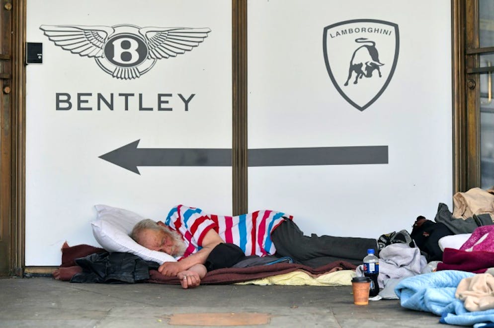 Un SDF dort devant l'entrée d'un concessionnaire de voitures de luxe, le 10 juin 2018 à San Francisco, en Californie