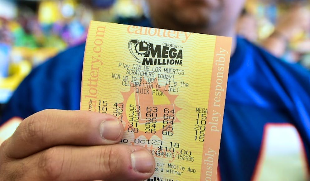 Un homme montre son ticket avant le tirage du super jackpot de 1,6 milliard, acheté dans une épicerie de Hawthorne, en Californie, le 23 octobre 2018
