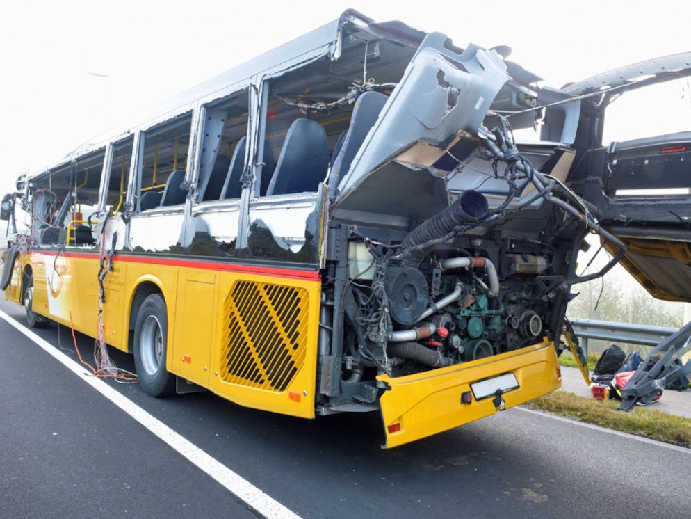 Huit blessés dans une collision bus-camion. Le bus de ligne de CarPostal a été éventré, sur le côté et à l'arrière, par la ridelle latérale ouverte du camion.