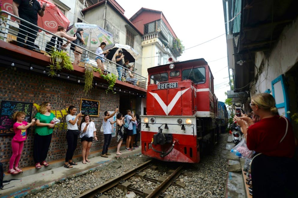 Des touristes prennent en photo un train qui passe dans le vieux quartier de Hanoï; le 20 octobre 2018
