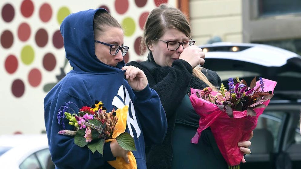Des personnes bouleversées déposent des fleurs sur les lieux de l'accident.