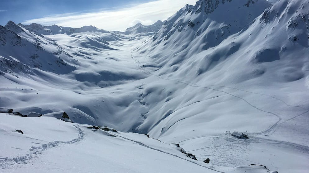 Skitour im Bündner Oberland. Nach einem kurzen Stopp in der Maighelshütte machen wir uns auf den Weg auf den Piz Cavradi.