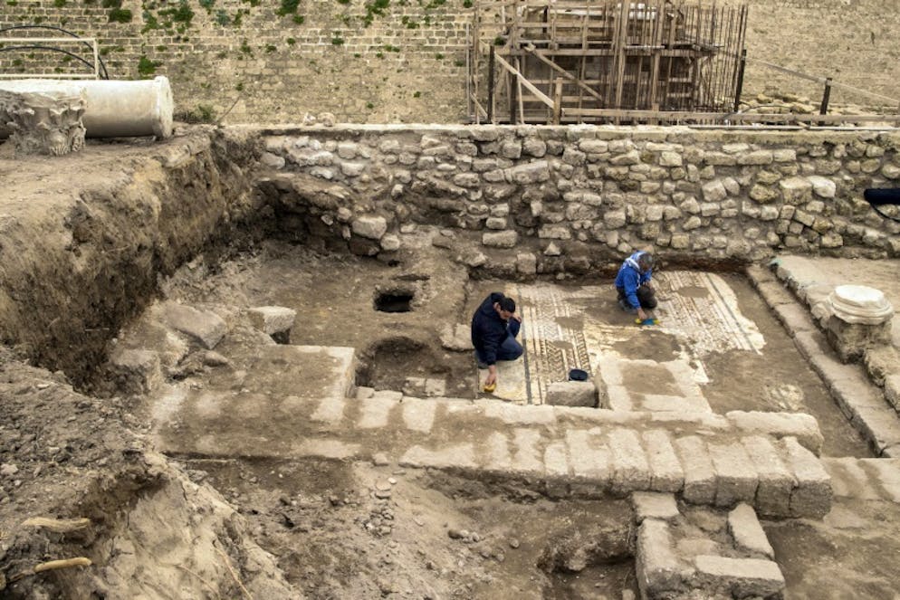 Une rare mosaïque de l'époque romaine découverte en Israël. Des employés de l'Autorité israélienne des Antiquités nettoyent une rare mosaïque de l'époque romaine découverte dans le port antique de Césarée, dans le nord d'Israël, et présentée le 8 février 2018