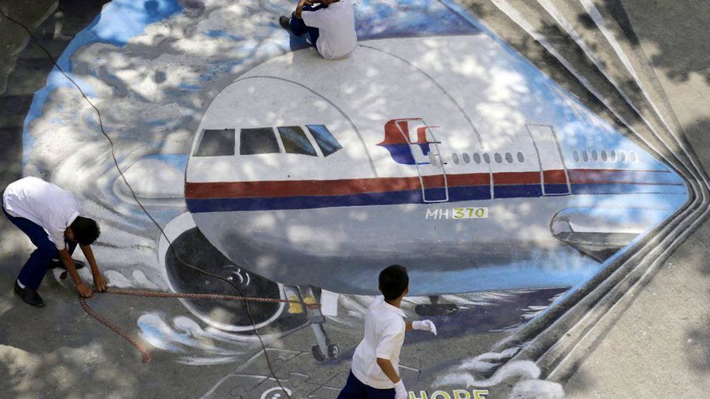 Die erfolglose Suche nach MH370. Philippinische Schüler zeichnen in Manila ein Bild der verschollenen Maschine von Flug MH370 auf den Asphalt.