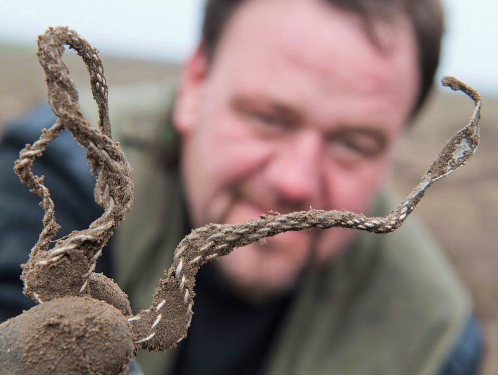 Auf der Flucht vergraben? Einmaliger Schatz auf Rügen entdeckt. Hier zeigt Schön zeigt nach der Ausgrabung einen kunstvoll geflochtene Silberhalsring aus dem Schatz von Schaprode.