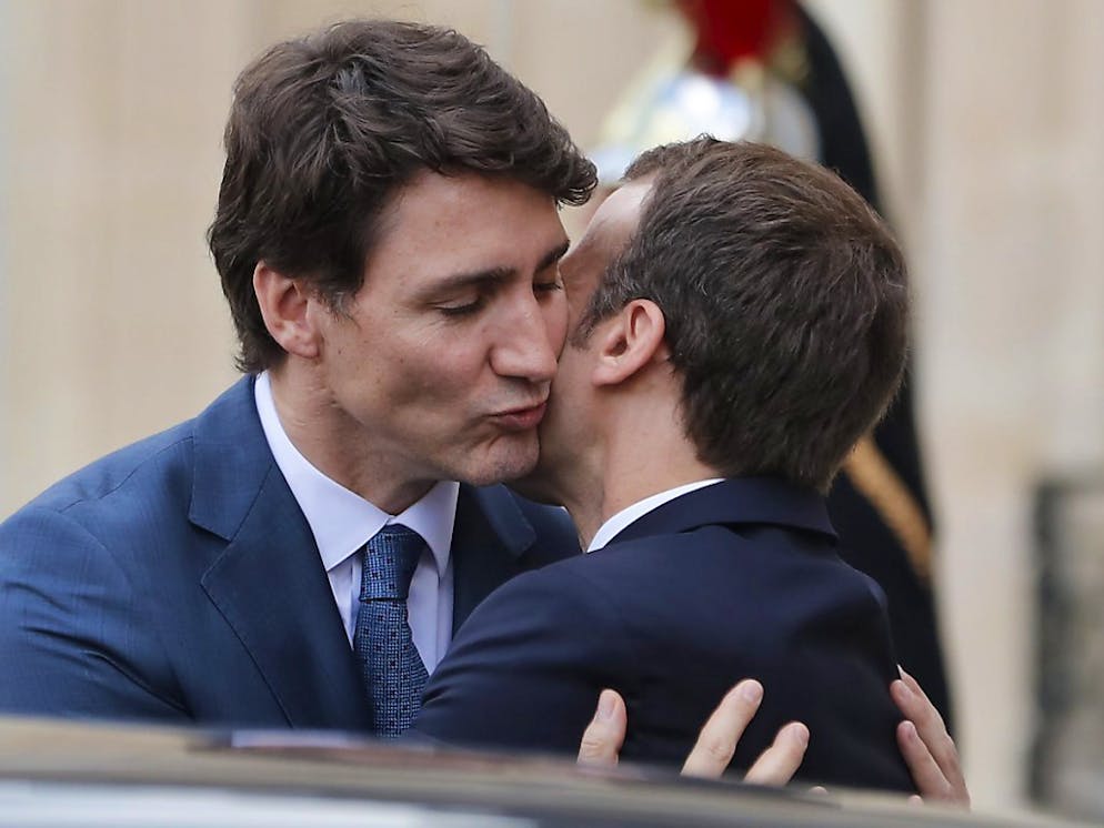 Justin Trudeau (l) und Emmanuel Macron umarmen sich vor dem Elysée-Palast
