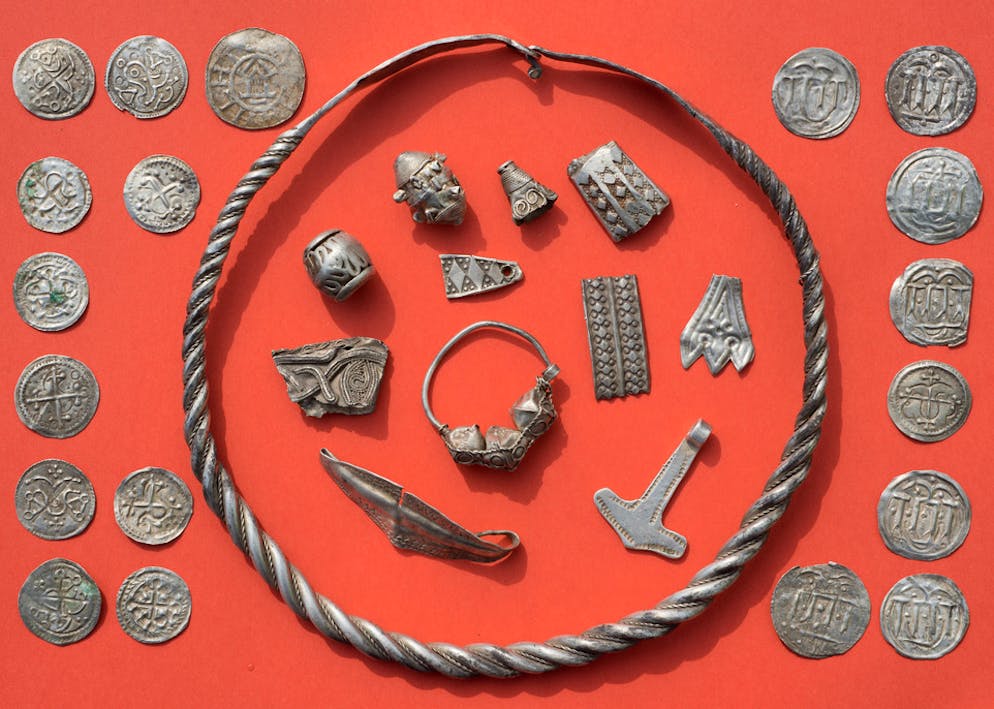 Auf der Flucht vergraben? Einmaliger Schatz auf Rügen entdeckt. Archäologen und Grabungshelfer entdeckten in der Folge kunstvoll geflochtene Halsreife, Perlen, Fibeln, einen Thorshammer, zerhackten Ringschmuck und zwischen 500 bis 600 teils zerhackte Münzen.