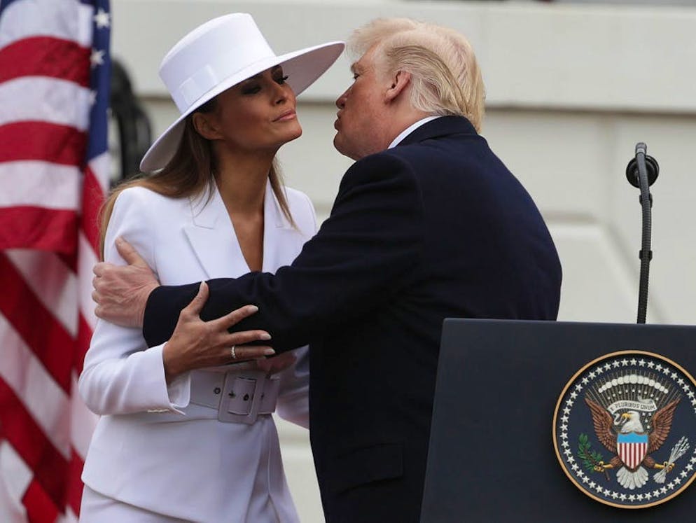 Il cappello di Melania Trump fa parlare di sé. ...e di limitare gli slanci di affetto del marito.