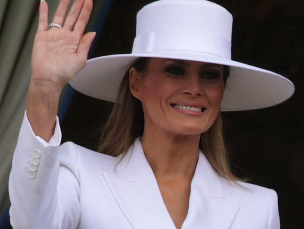 Il cappello di Melania Trump fa parlare di sé. Il sorriso rivolto ai fotografi è apparso forzato.