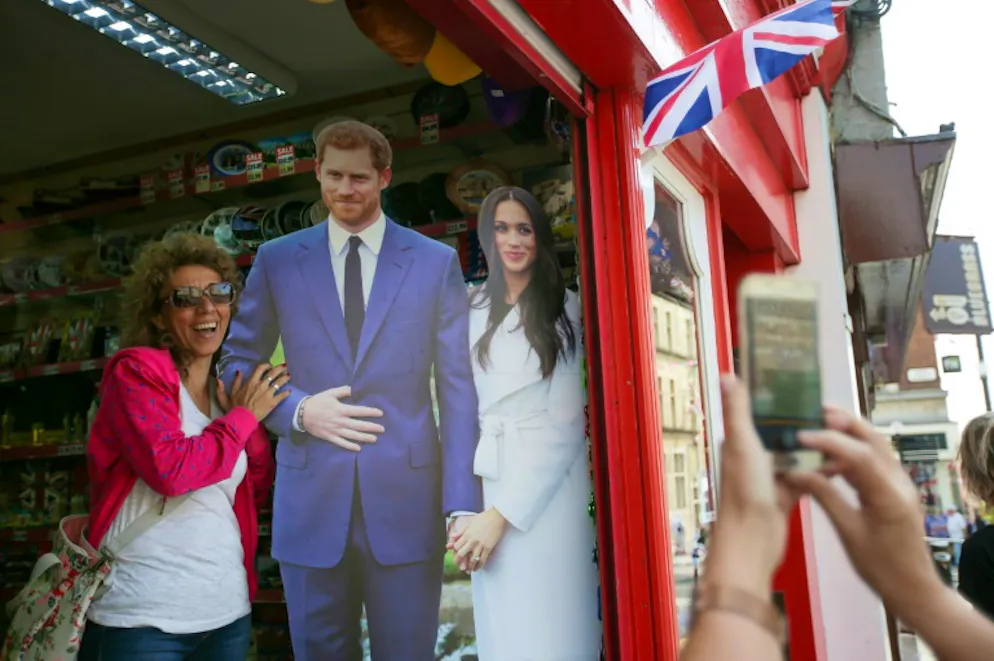 Mes beaux-parents et moi: la future famille américaine du prince Harry fait des siennes. Une touriste pose avec un portrait en carton du prince Harry et de sa fiancée Meghan Markle à Windsor le 8 mai 2018