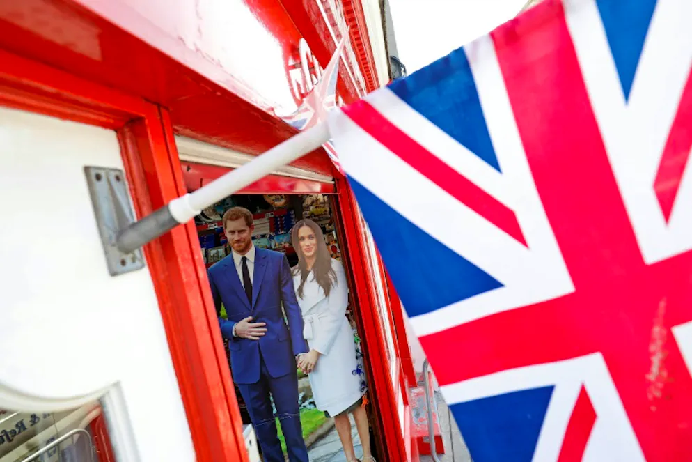 Mariage royal: le père de Meghan confirme son absence pour raisons médicales. Une photo du prince Harry et de sa fiancée Meghan Markle affichée devant une boutique de souvenirs près du château de Windsor, le 15 mai 2018