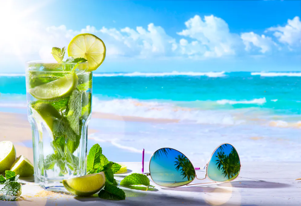 tropic summer vacation; Exotic drinks on blur tropical beach background