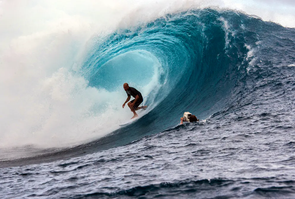 Tahiti, future destination accessible à la mode ?. TOPSHOTS
A cameraman floats in the water filming USA's Kelly Slater as he competes in the 2015 Billabong Pro Tahiti, World Surf league tour no.7, along the Teaupoo coast, western Tahiti on August 15, 2015. Australia's Mick Fanning made his first appearance in this competition since being attacked on July 19 by a shark in the Final of the J-Bay Open, off the coast of South Africa. AFP PHOTO/ GREGORY BOISSY