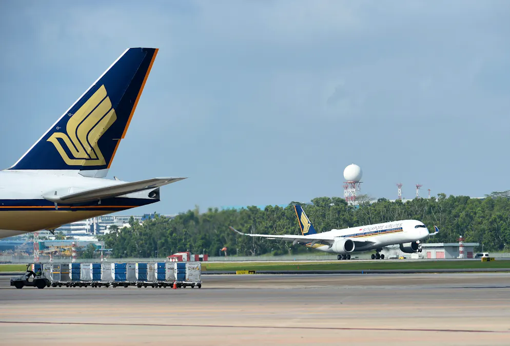 (FILES) In this file photo taken on March 3, 2016 a Singapore Airlines Airbus A350-900 (R) lands at Singapore International Changi airport.
Singapore Airlines said on May 30, 2018 that it will launch the world's longest commercial flight in October, a journey of almost 19 hours from the city-state to New York, but it will not be available to economy travellers.  / AFP PHOTO / Roslan RAHMAN