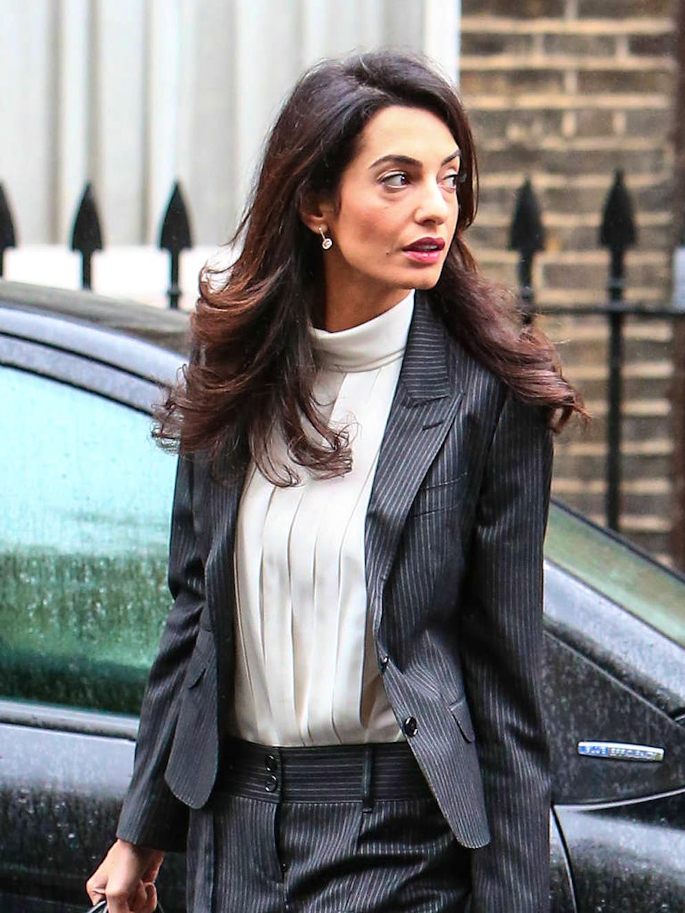 Amal Clooney en 11 looks. Le combo look androgyne/petite blouse en voile de soie avec des stillettos est un sans faute, et ce, quelle que soit la saison ou la circonstance. On adore !