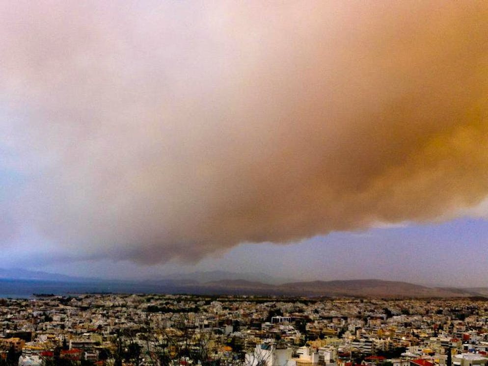 Brände in Griechenland. Eine Rauchwolke färbt Teile des Himmels über Athen orange. 