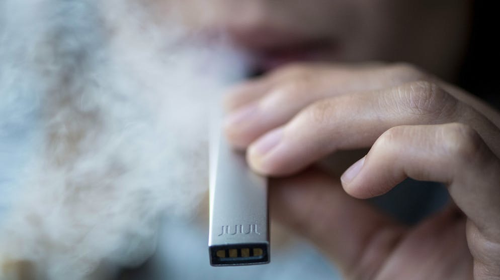 Eine Frau raucht eine E-Zigarette vom kalifornischen Marktführer Juul, der wegen zweifelhafter Methoden bei der Vermarktung und Jugendschutz-Bedenken schon länger in der Kritik steht.