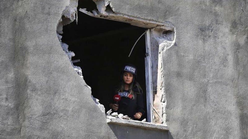 Hilfe für Kurden: Assad verlegt Truppen an türkische Grenze. Eine Journalistin schaut aus einem Loch in der Wand eines Hauses in Akçakale, das von einem Mörser aus Syrien beschädigt wurde. Niemand wurde durch den Angriff verletzt.