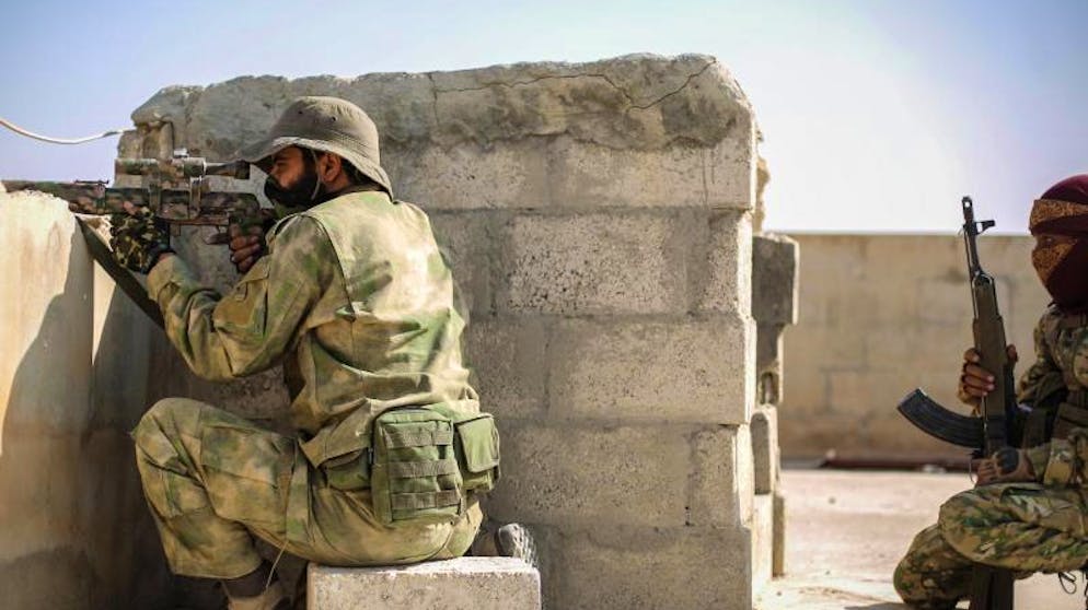 Hilfe für Kurden: Assad verlegt Truppen an türkische Grenze. Ein Scharfschütze der mit der Türkei verbündeten Syrischen Nationalarmee zielt mit einer Waffe von einem Dach in Tall Abjad.