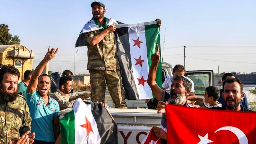 Hilfe für Kurden: Assad verlegt Truppen an türkische Grenze. Syrische Oppositionskämpfer, die von der Türkei unterstützt werden, jubeln im türkischen Grenzort Akcakale.