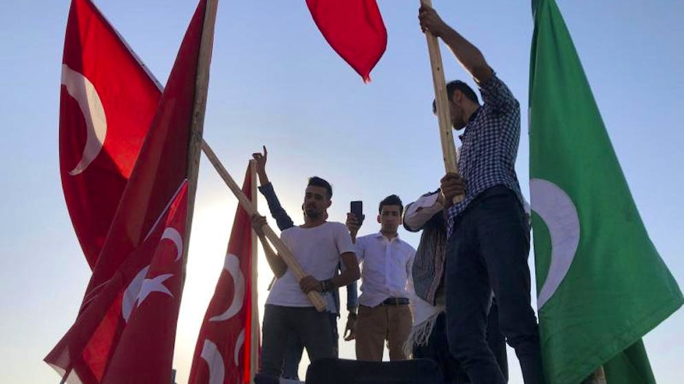 Hilfe für Kurden: Assad verlegt Truppen an türkische Grenze. Männer schwenken in Akçakale Nationalflaggen und feiern die Erfolge der türkischen Truppen. 