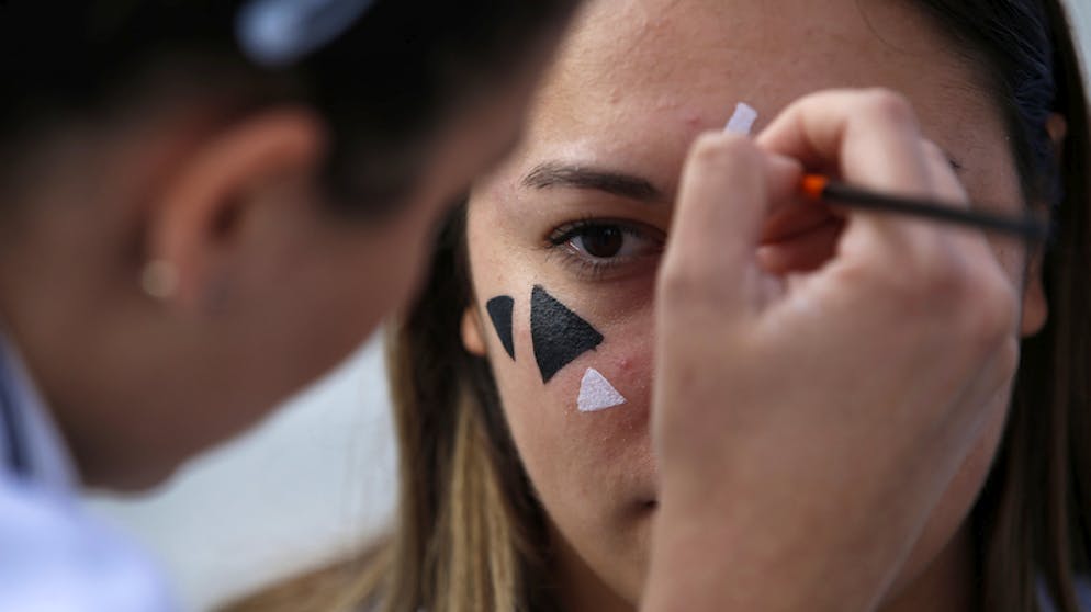 Chinesische Aktivisten bemalen ihr Gesicht, um die Gesichtserkennung der Kameras zu verwirren.