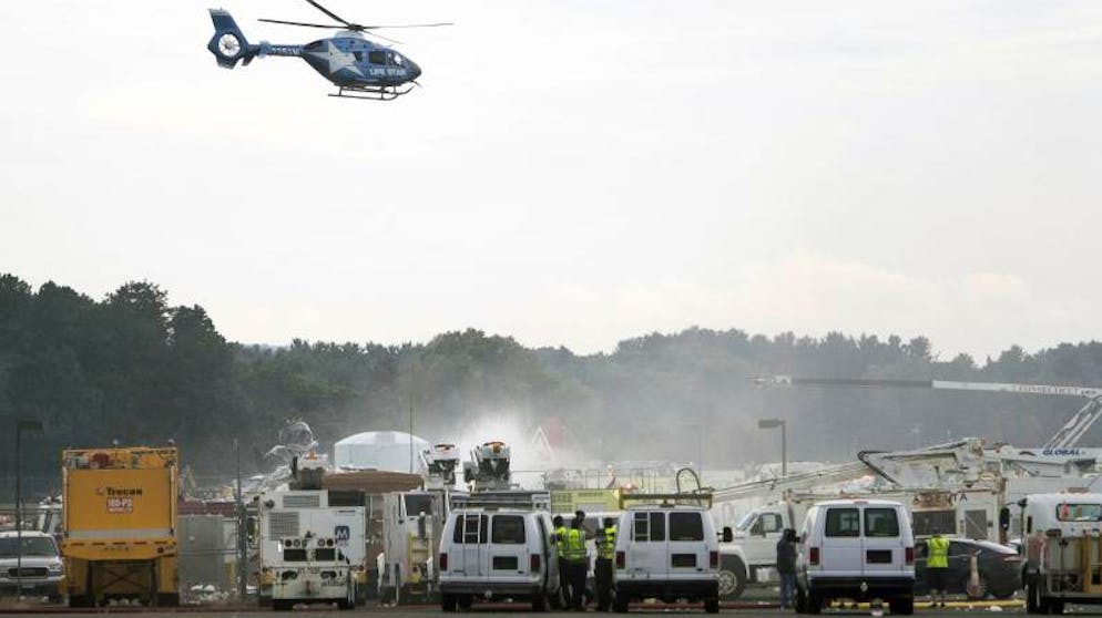 Ein Rettungshelikopter fliegt über dem Absturzort des B-17-Bombers am Bradley International Airport. Bei dem Unglück sind mindestens 14 Menschen verletzt worden.