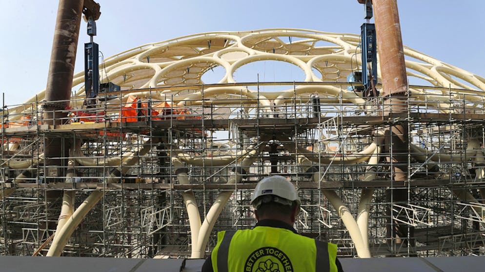 Ein Bauarbeiter steht von dem im Bau befindlichen Al Wasl Dome.