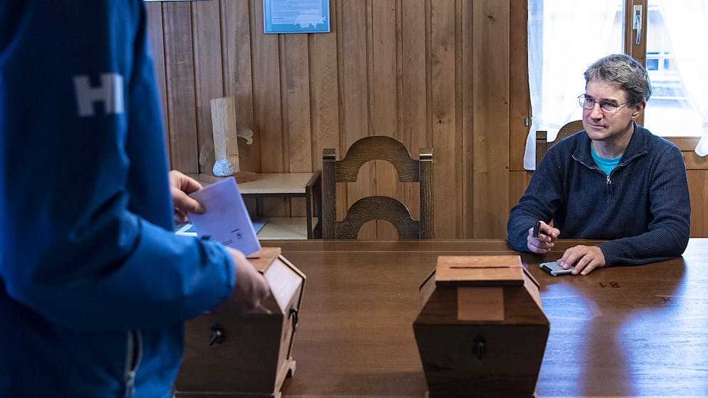 Wahlsonntag in Kleinstgemeinden. Gemeinderat Urs Zuberbühler überwacht die Stimmabgabe, am Wahltag in Guttannen. (KEYSTONE/Peter Schneider)