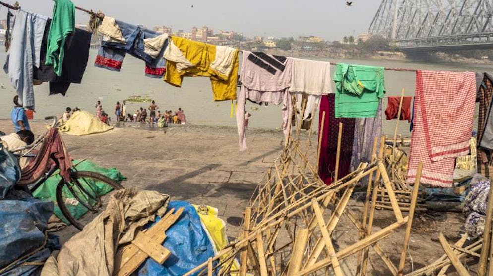 Kalkutta – bunte Metropole am Ganges. Am Mündungsarm des Hugli führt die belebte Howrah Bridge über den Fluss.