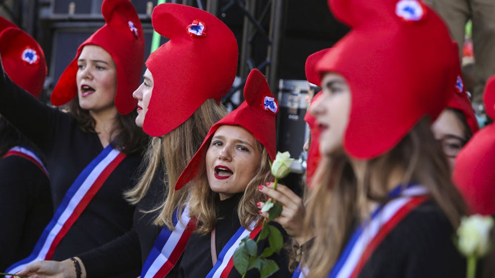 Eher konservative Frauen protestieren in Paris. Sie tragen die sogenannte Freiheitsmütze (phrygische Mütze) der Jakobiner der Französischen Revolution, die in der politischen Ikonografie Frankreichs und ganz Europas zum Symbol demokratischer und republikanischer Gesinnung wurde.