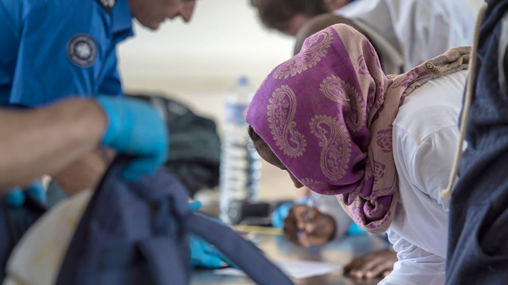 Flüchtlinge und Personal des Grenzwachtkorps bei der Grenzkontrolle am Zoll des Bahnhofs Chiasso.