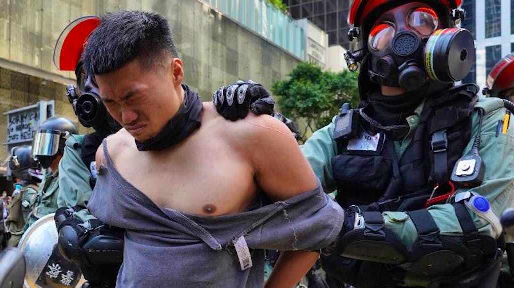 Polizisten nehmen in Hongkong einen Demonstranten fest. Nach dem Tod eines Studenten sind die Proteste in der chinesischen Sonderverwaltungszone neu entflammt. Ein Demonstrant wurde angeschossen.