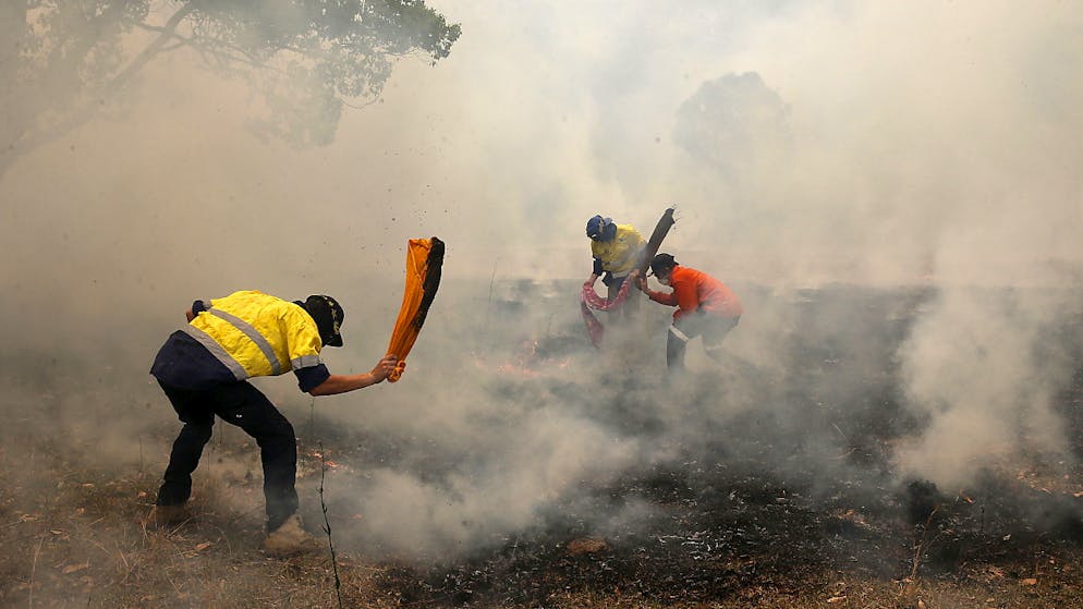 Bewohner im Buschbrandgebiet in Australien versuchen in Handarbeit eine Ausbreitung des Feuers zu verhindern.