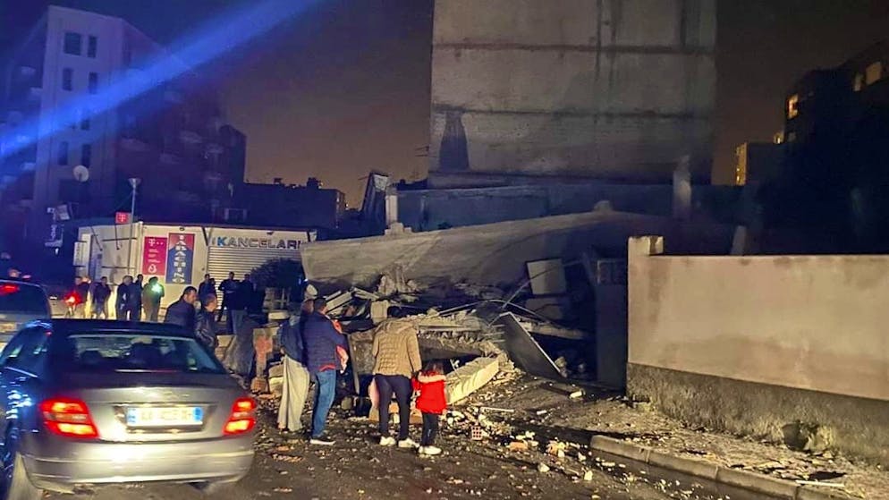 Schweres Erdbeben erschüttert Albanien. Menschen stehen in Durres vor einem beschädigten Gebäude.