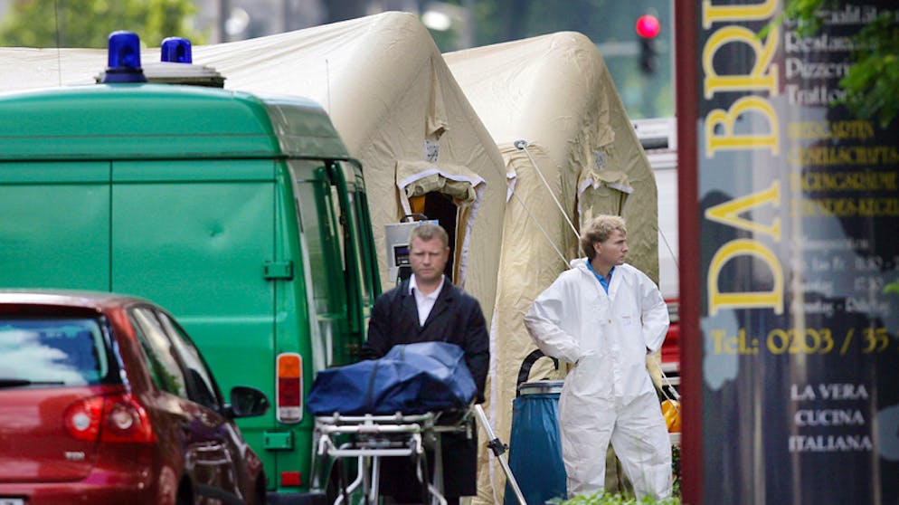 Ein Bestatter schiebt eine Trage mit einer verdeckten Leiche von einem Tatort. Sechs Menschen wurden 2007 vor einer Pizzaria in Duisburg erschossen.