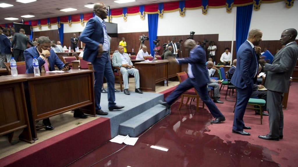 Inondation au parlement: à Port-au-Prince (Haïti), un député enjambe une flaque d’eau qui s’est formée dans le parlement suite à une fuite dans la toiture.