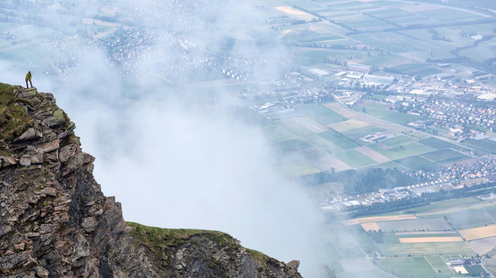 Ein Bergwanderer blickt vom Vorgipfel des Vilan auf das Churer Rheintal.  
