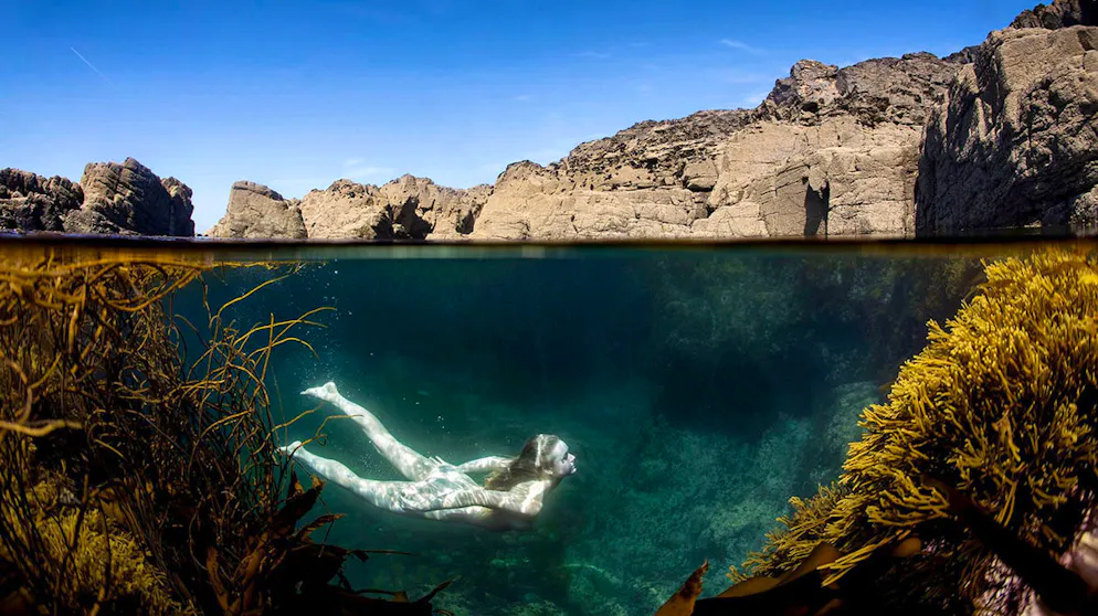Alte Bergwerke in Cornwall laden heute zum Schwimmen ein. Linda Evans schwimmt im kristallklaren Wasser eines mit Meerwasser befüllten Pools in einem alten Tagebau in Cornwall.