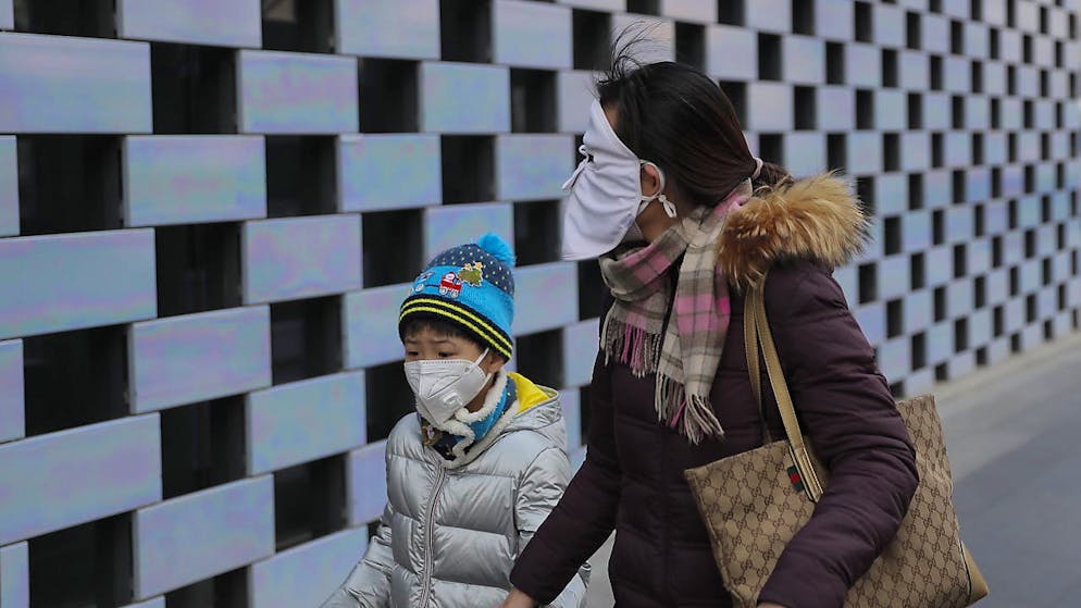 Die durch das Coronavirus hervorgerufene Lungenkrankheit aus China verbreitet sich weiter – überall auf der Welt schützen sich Menschen mittlerweile wie hier im Bild in Peking mit Schutzmasken.