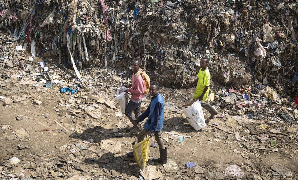 Mohamed Nassur, 17, left, Peter Kihika, 16, center, and Dominic Munyoki, 15, right, scavenge for scrap metal to sell at Kenya's largest landfill Dandora where Mohamed now works after his mother lost her job and his school was closed due to the coronavirus pandemic, in Nairobi, Kenya Saturday, Sept. 26, 2020. The United Nations says the COVID-19 pandemic risks significantly reducing gains made in the fight against child labor, putting millions of children at risk of being forced into exploitative and hazardous jobs, and school closures could exacerbate the problem. (AP Photo/Brian Inganga)